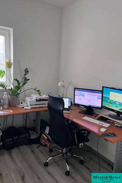 Domácí kancelář s počítačem a podlahou s dřevěným dekorem ve 4-pokojovém bytě.