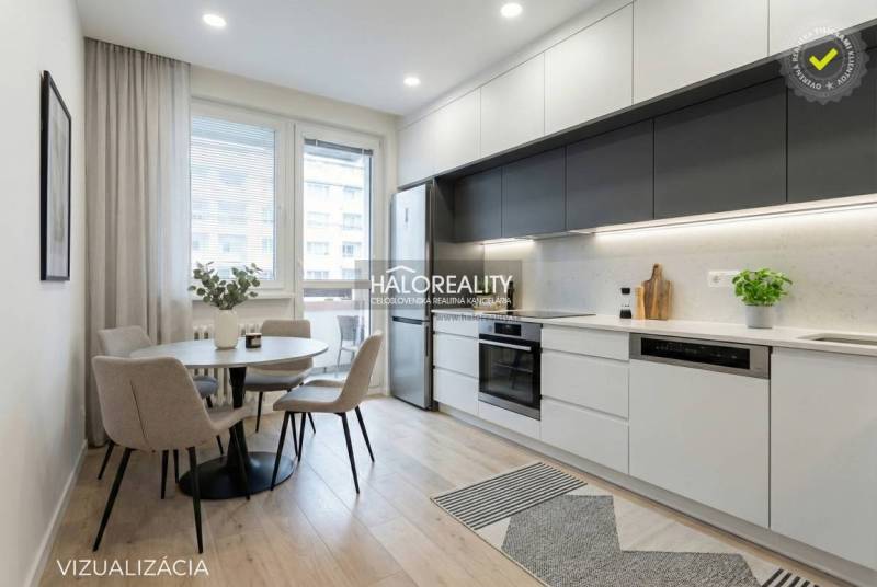 Jídelní kout s kulatým stolem a kuchyně s linkou ve 3-pokojovém bytě.