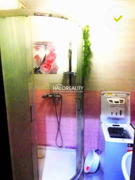 Koupelna v 2-pokojovém bytě se sprchovým koutem a pračkou, barevně laděná do růžova.