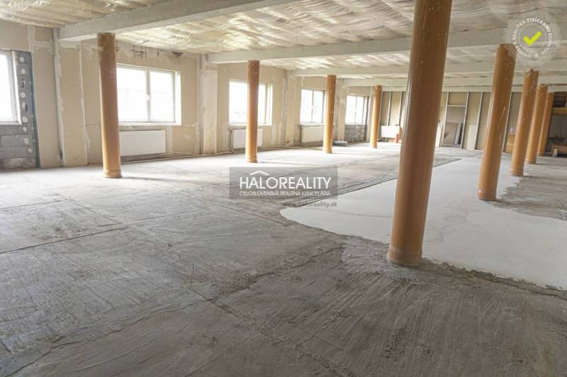 Obchodní prostory s otevřeným prostorem a odhalenými dřevěnými sloupy.