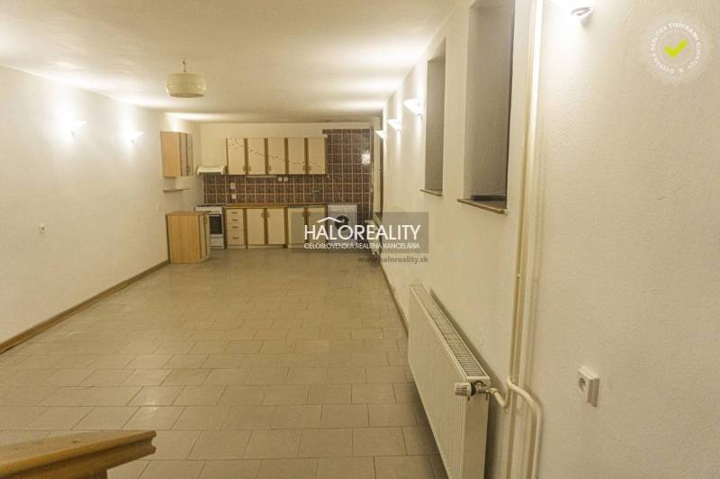 Prostorná kuchyně a jídelna v rodinném domě s dlažbou a světlým osvětlením.