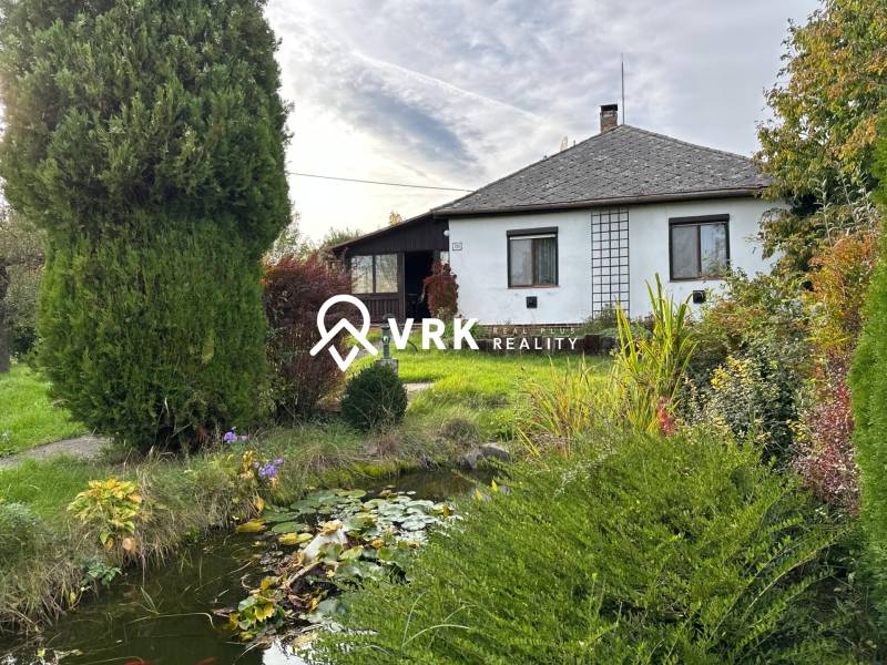 Rodinný dům v Kalši s krásnou zahradou a malým jezírkem obklopeným zelení.
