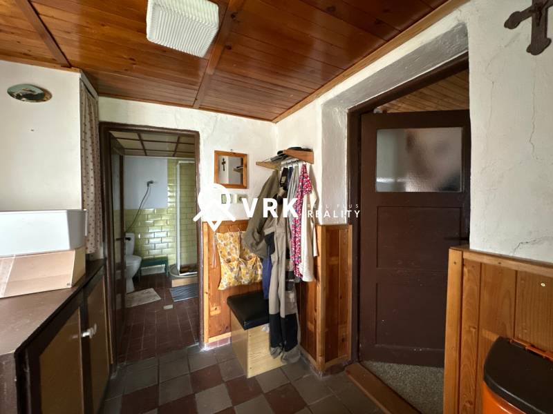 Interiér rodinného domu se vstupem do koupelny a věšáky na oblečení.