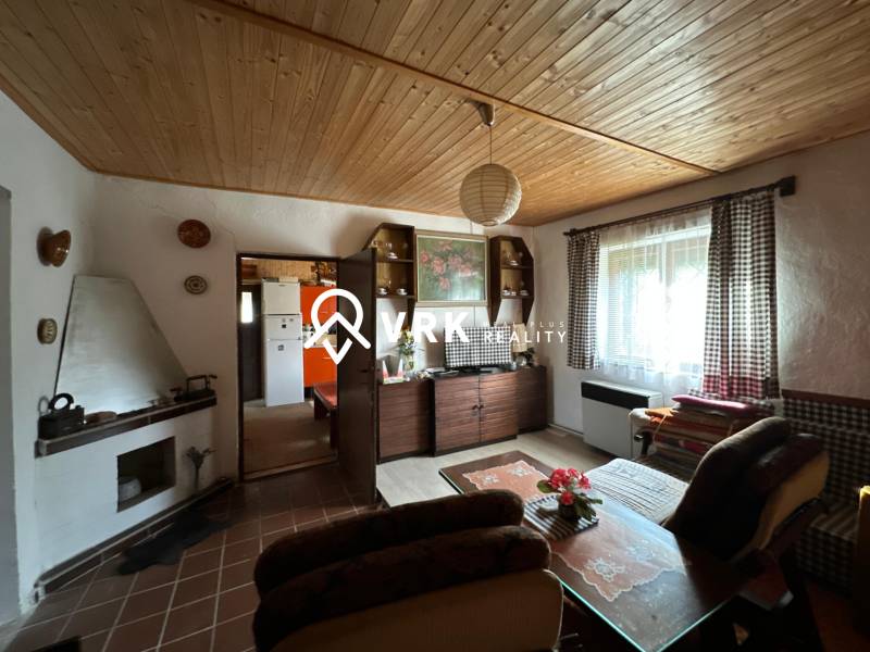 Obývací pokoj v rodinném domě s dřevěným dekorem stropu a útulným nábytkem.