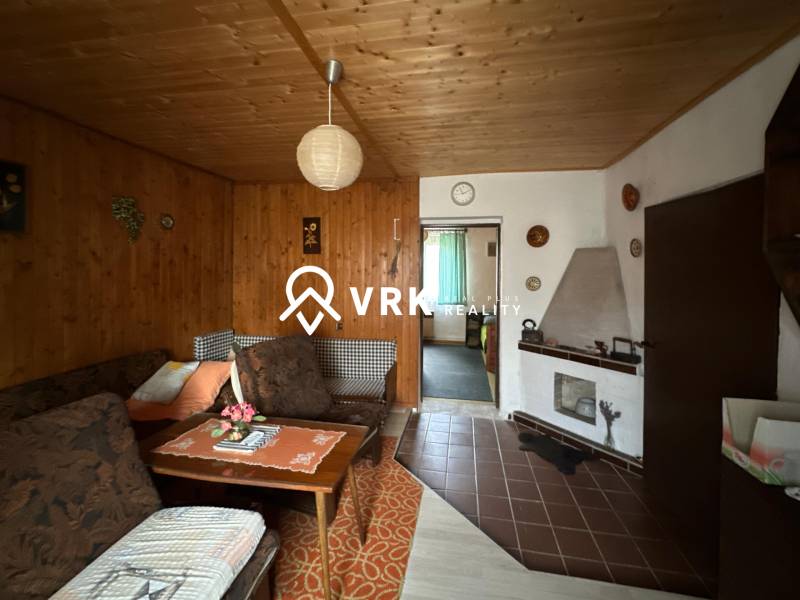 Obývací pokoj v rodinném domě s dřevěným dekorem stěn a stropu.