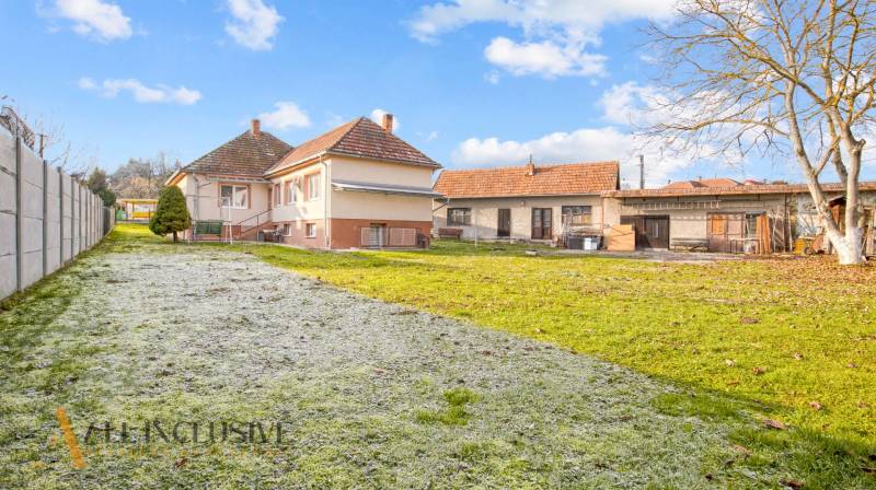 Rodinný dům na Nemečkovské ulici v Prašicích s velkou zahradou a budovami v pozadí.