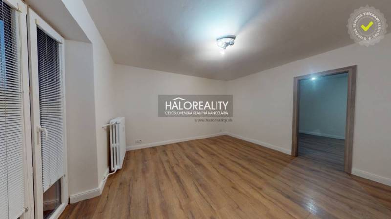 Prostorný pokoj v 2-pokojovém bytě s podlahou s dřevěným dekorem a radiátorem.