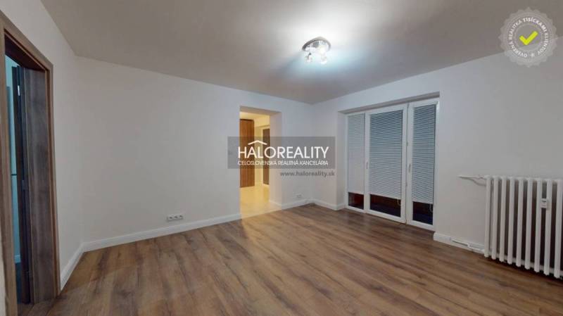 Obývací pokoj v 2-pokojovém bytě s podlahou s dřevěným dekorem a francouzským oknem.