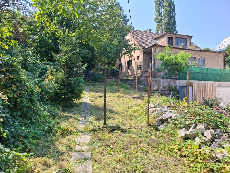 Rodinný dům na Búdkové ulici v Bratislavě - Staré Město, s chodníkem a stromy.