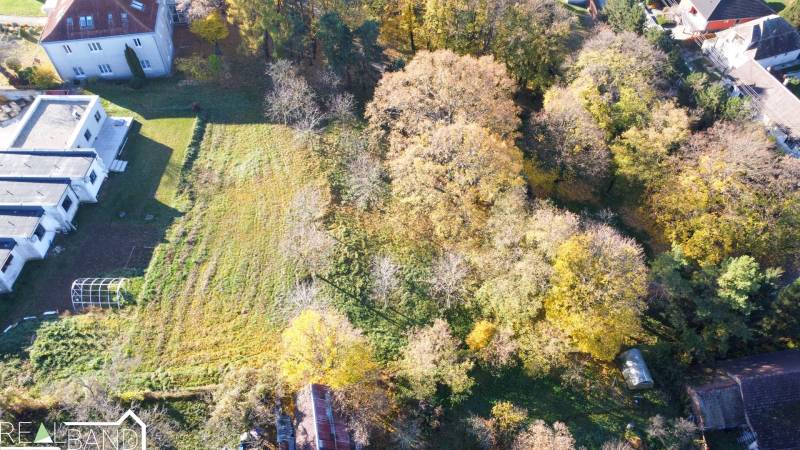 Letecký pohled na pozemky - komerční v Suchej nad Parnou, obklopené zelení a budovami.