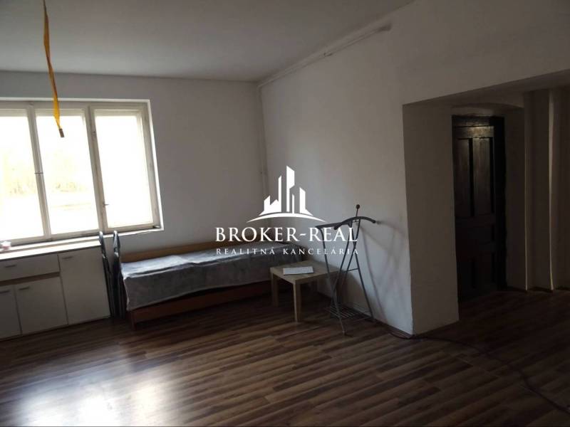 Rodinný dům s podlahou s dřevěným dekorem, oknem a nábytkem.