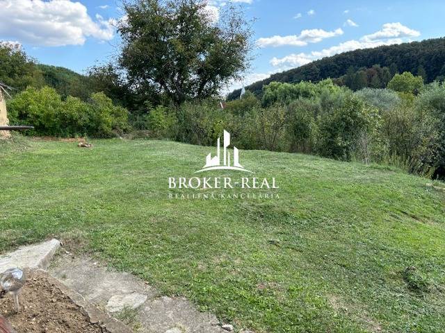 Zahrada u rodinného domu v Rudabáni, obklopená zelení a kopci, ideální prostor k relaxaci.