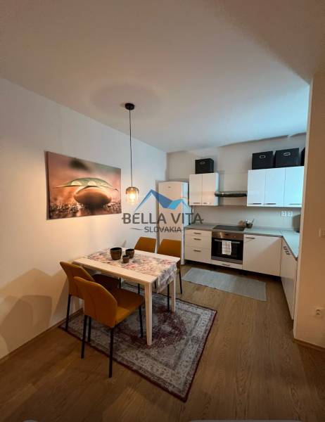 Kuchyně a jídelna v 2-pokojovém bytě s podlahou s dřevěným dekorem.