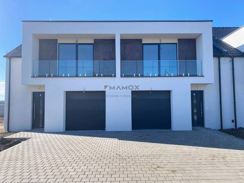 Rodinný dům na Polnokesovské ulici v Mojmírovicích se skleněným balkonem a dvojgaráží.