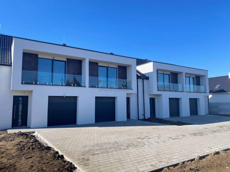 Rodinný dům na Polnokesovské ulici v Mojmírovcích s prosklenými balkóny a garážemi.