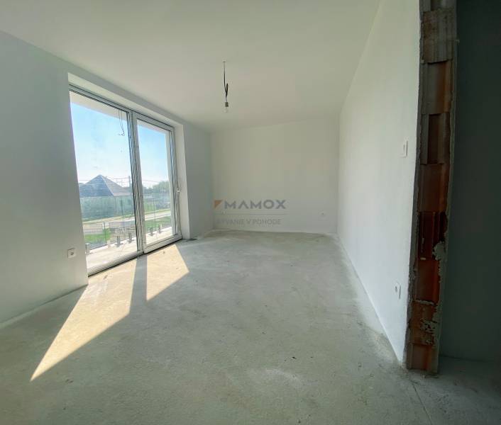 Neposkvrněná místnost s velkým oknem, podlaha s cementovým povrchem v rodinném domě.