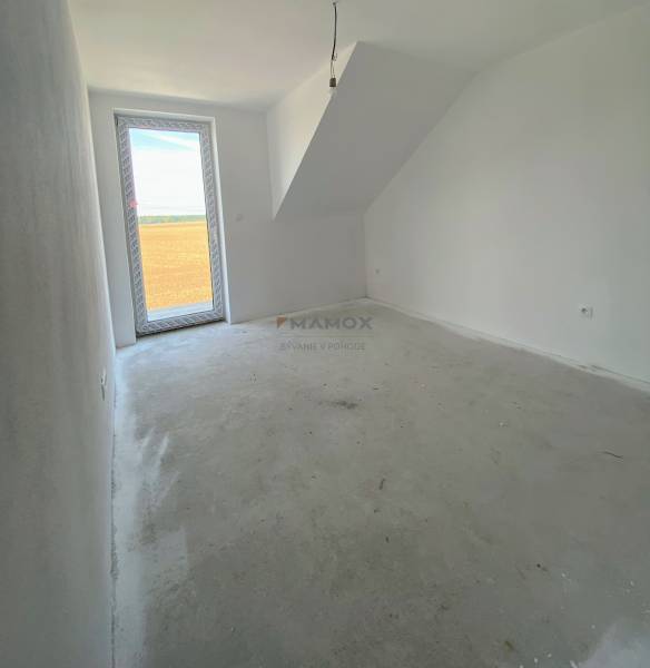 Pokoj v rodinném domě se skleněnými dveřmi a šikmým stropem, prázdná podlaha.