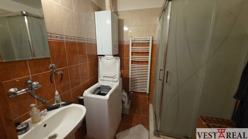 Koupelna v 3-pokojovém bytě s pračkou, sprchovým koutem a keramickým obkladem.