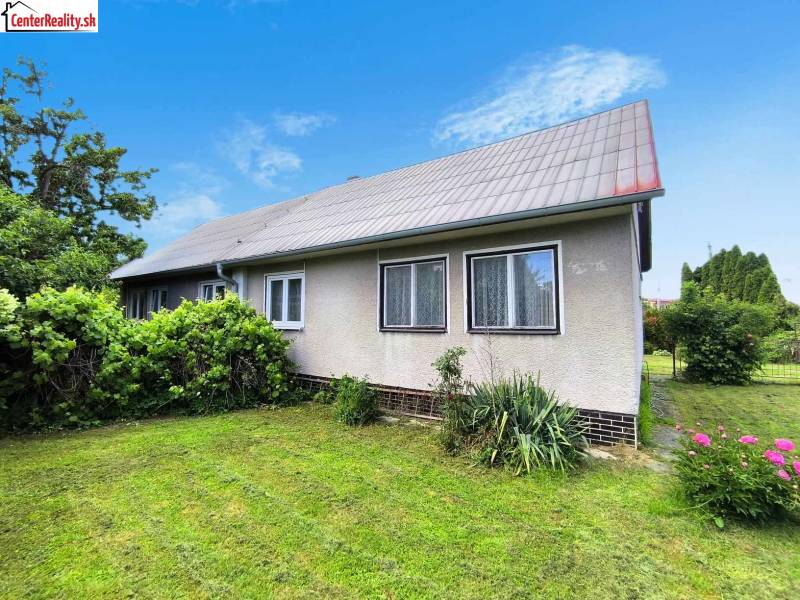 Rodinný dům v Novácích se zahradou, trávníkem a okrasnými keři.