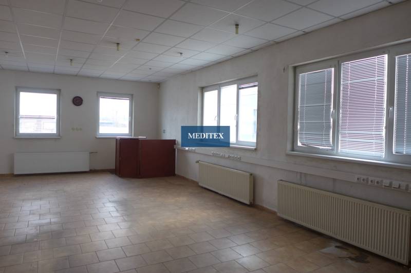 Kancelářský prostor ve skladech a halách se světlou dlažbou a velkými okny.