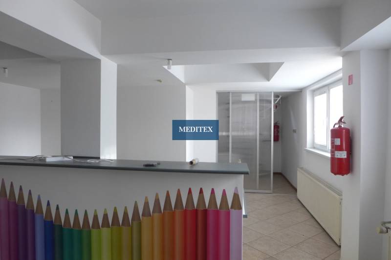 Interiér sklady a haly s recepčním pultem zdobeným barevnými tužkami a požárním hydrantem.