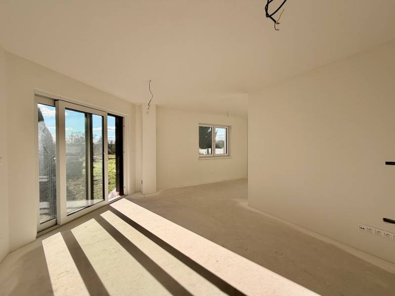 Prostorná místnost s velkými okny a výhledem v rodinném domě.