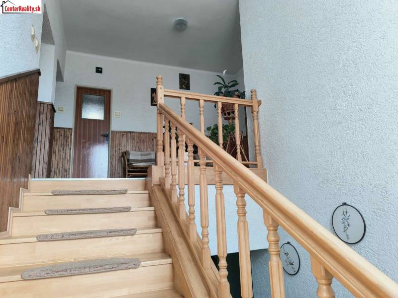 Rodinný dům s dřevěným schodištěm, obložením stěn a dekorací.