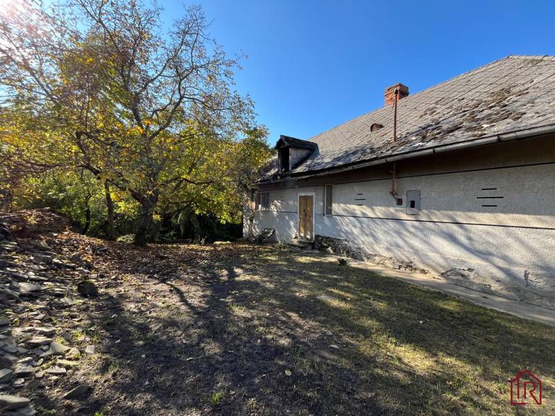 Dvorec s domem v Rákoši, obklopený zelení. Pozemky - bydlení.