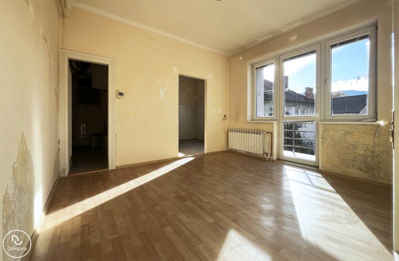 Pokoj v bytě s pěti a více pokoji se slunečním světlem a podlahou s dřevěným dekorem.