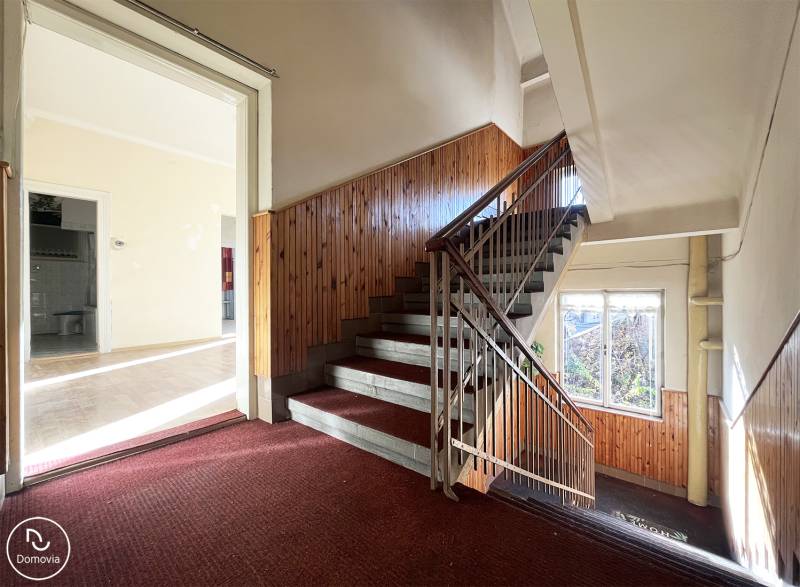 Schodiště a vstup do 5 a více pokojového bytu s podlahou s dřevěným dekorem.