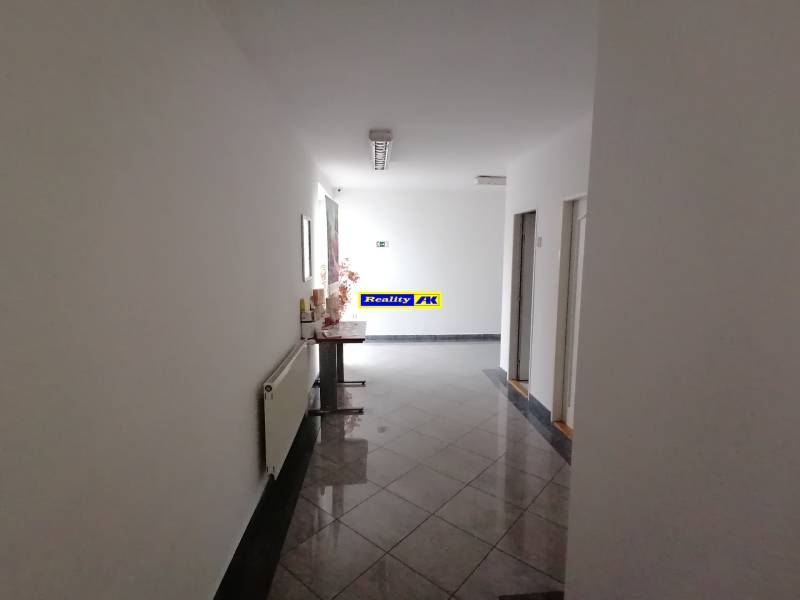 Chodba kanceláří s dlažbou a dekorací.