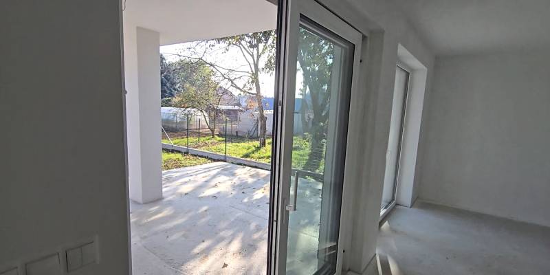 Okna a dveře v rodinném domě vedoucí na terasu, výhled na zahradu.