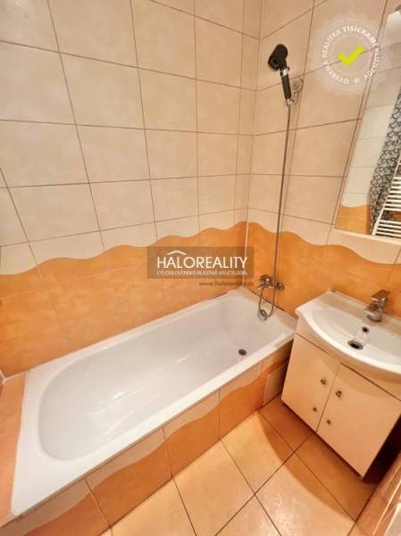 Koupelna ve 4-pokojovém bytě se sprchovací vanou a umyvadlem.