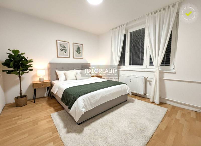 Světlá ložnice v 2-pokojovém bytě s podlahou s dřevěným dekorem, dekorací a velkým oknem.