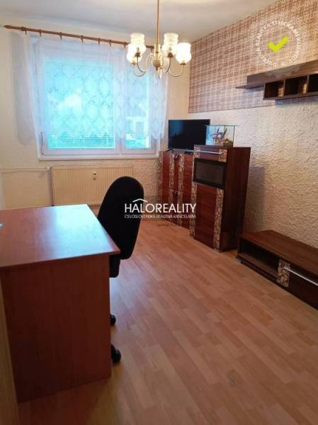 Pokoj s podlahou s dřevěným dekorem, kancelářským stolem a policemi ve 3-pokojovém bytě.