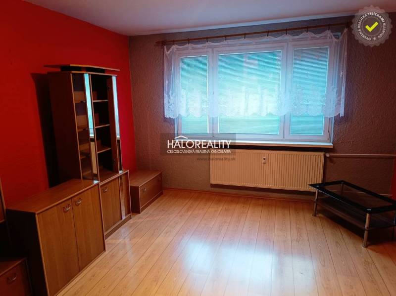 Pokoj s podlahou s dřevěným dekorem, červenými stěnami a nábytkem v 3-pokojovém bytě.