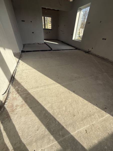 Interiér rodinného domu s betonovou podlahou a velkými okny z Mostu u Bratislavy.