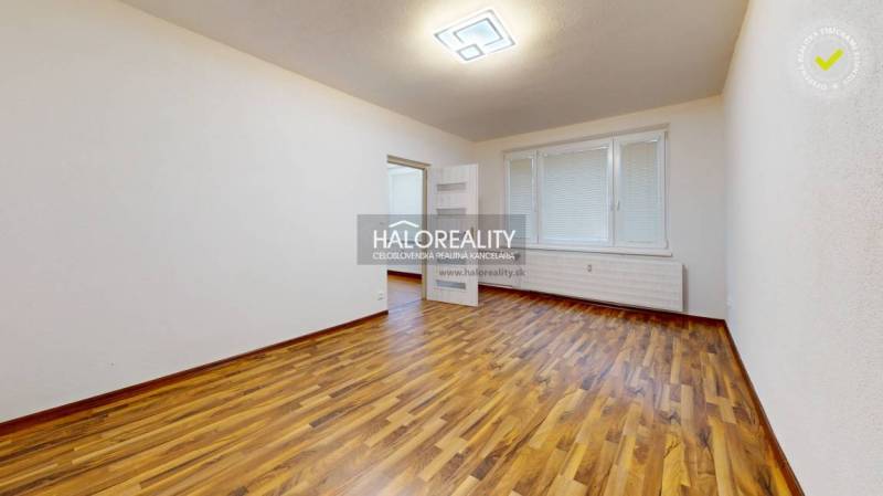 Prostorný pokoj s podlahou s dřevěným dekorem v 1-pokojovém bytě.