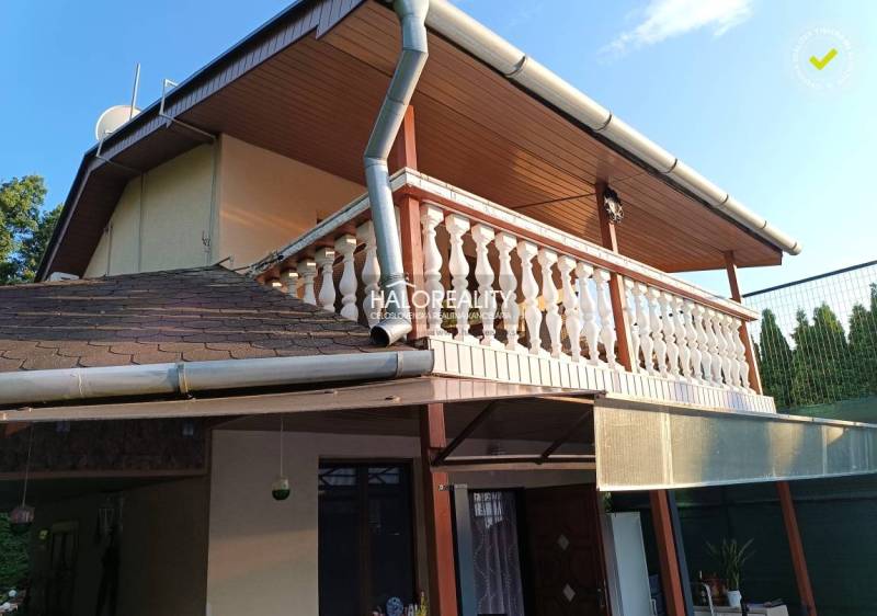 Chata v Byšte s terasou a dřevěným dekorem balkónu.