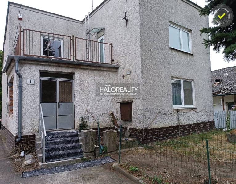 Rodinný dům na Zemplíně se schodištěm, balkonem a řídkým plotem.