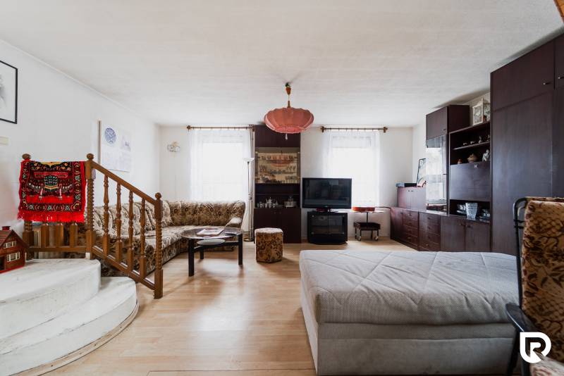 Obývací pokoj v rodinném domě s podlahou s dřevěným dekorem a pohodlným posezením.