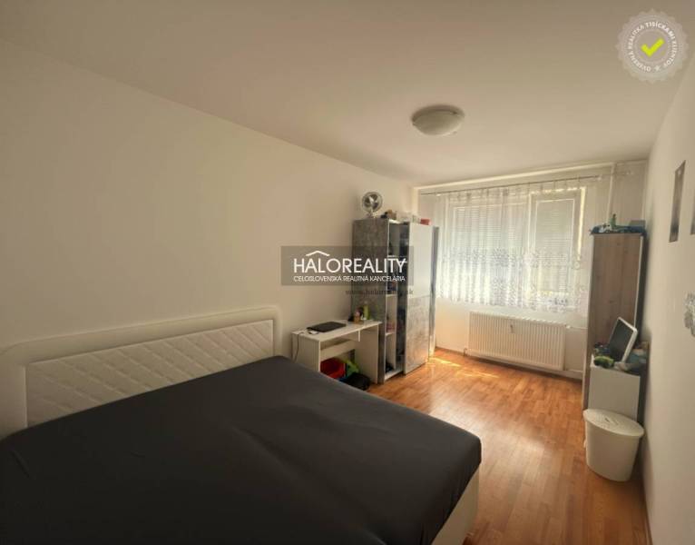 Ložnice ve 3pokojovém bytě s postelí, podlahou s dřevěným dekorem a úložnými prostory.