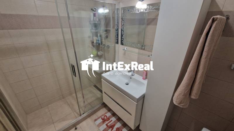 Koupelna s dlaždicemi a sprchovým koutem v 3-pokojovém bytě.