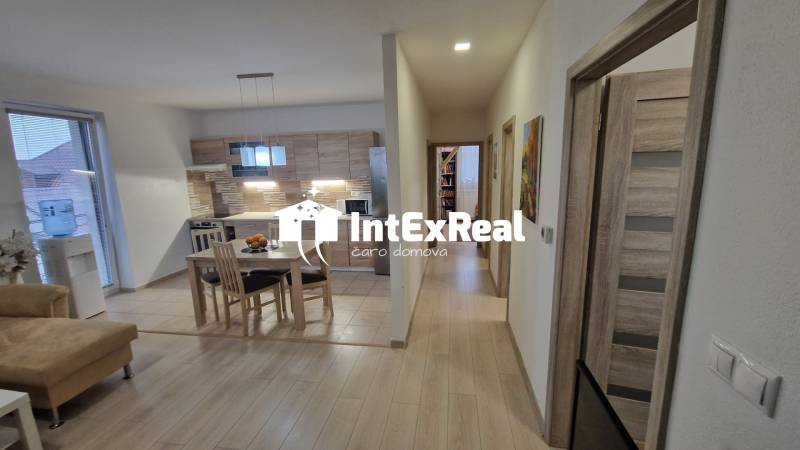 Interiér 3-pokojového bytu s kuchyní a podlahou s dřevěným dekorem.