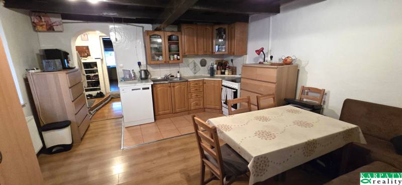 Kuchyně s dřevěným nábytkem a podlahou s dřevěným dekorem v rodinném domě.