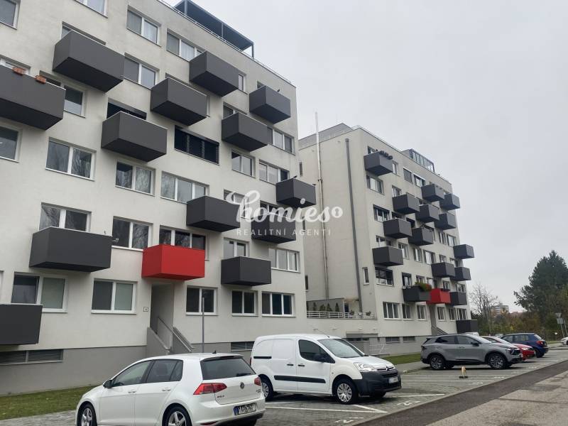 Bytovka na Lomnické ulici v Nitře s garážovými stáními a balkóny.