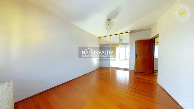 Pokoj v 3-pokojovém bytě s podlahou s dřevěným dekorem a vestavěnou skříní.