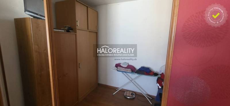 Šatník v 1-pokojovém bytě s dřevěným dekorem, úložné skříně, žehlící prkno.