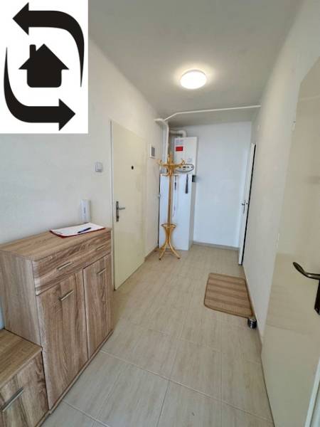 Vstupní hala ve 3-pokojovém bytě s dlažbou, botníkem a věšákovou stěnou.