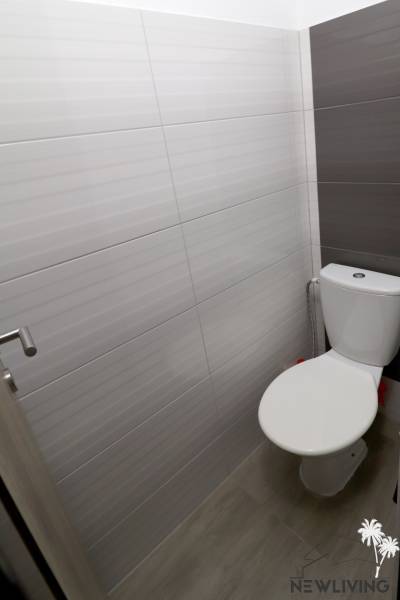 Koupelna v rodinném domě s moderními dlaždicemi a jednoduchým designem WC.